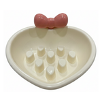 Heart-shaped dish with a pink bow on a white background