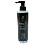 Black bottle of premium pet shampoo with pump on a wooden floor.