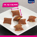 Small brown dog treats on a white plate with Vitakraft branding and size measurement text.