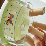 Glass lid with cartoon design and wooden handle held by a hand