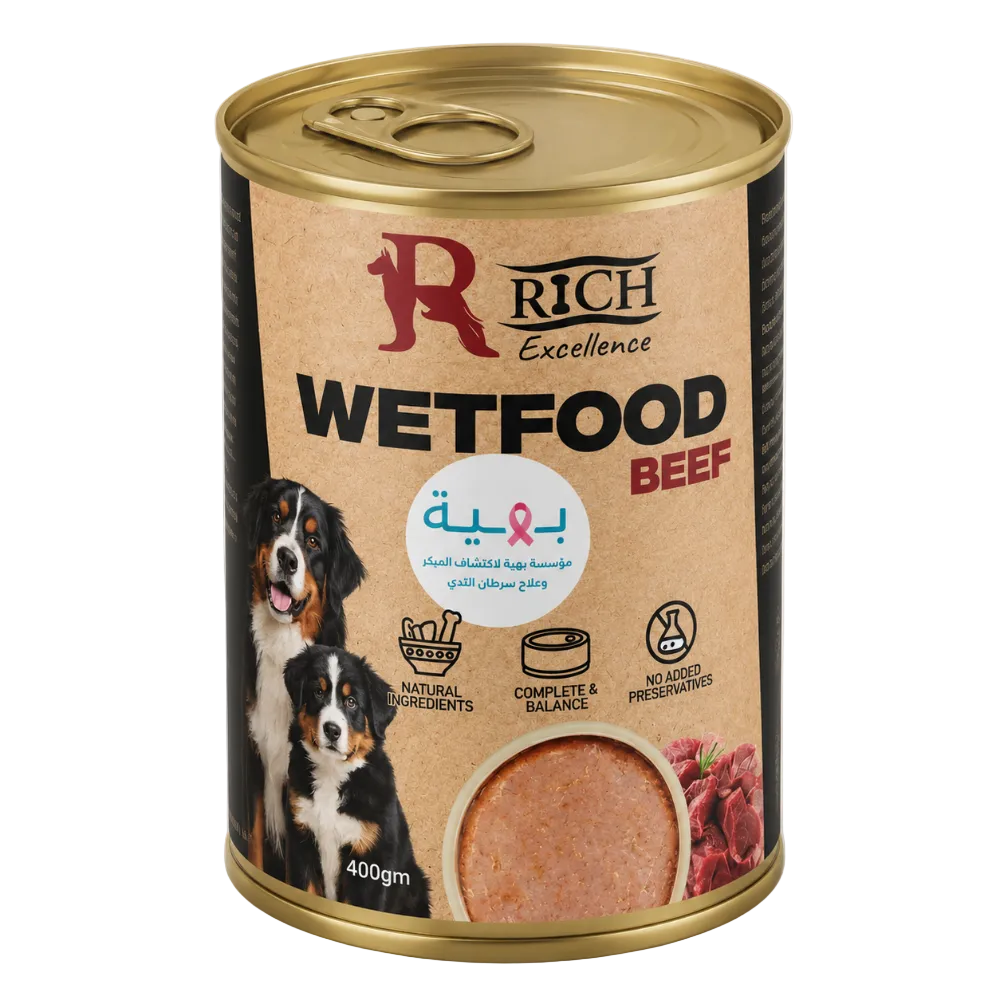 A can of Rich Excellence wet dog food, beef flavor, with a gold lid and base, and a beige label featuring a Bernese mountain dog and a photo of wet food. The label also contains Arabic text and icons indicating natural ingredients and complete balance.