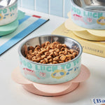 Pet bowl with pet food on a table with books in the background