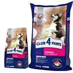Two packages of Club 4 Paws dog food for puppies on a white background